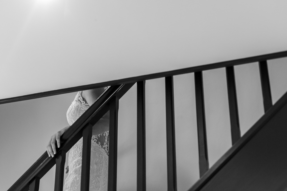 bride coming down steps  in her wedding dress 