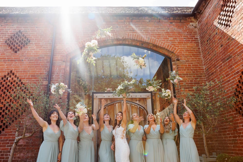 bride and bridesmaids throwing bouquets 