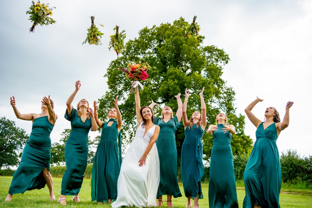 bride and bridesmaids throwing bouquets into the air