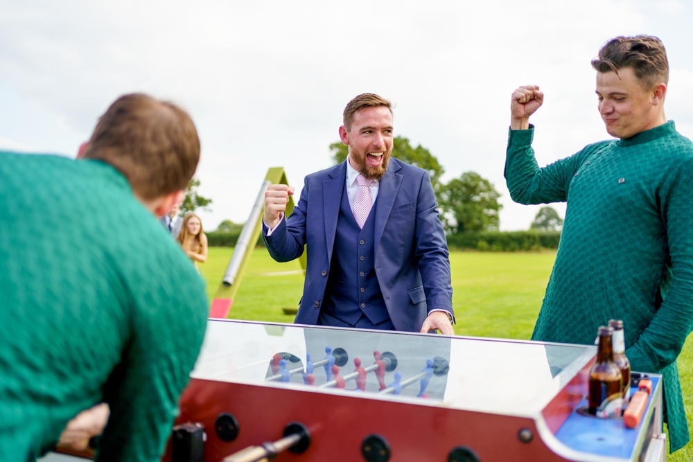 groomsmen playing on a football table 