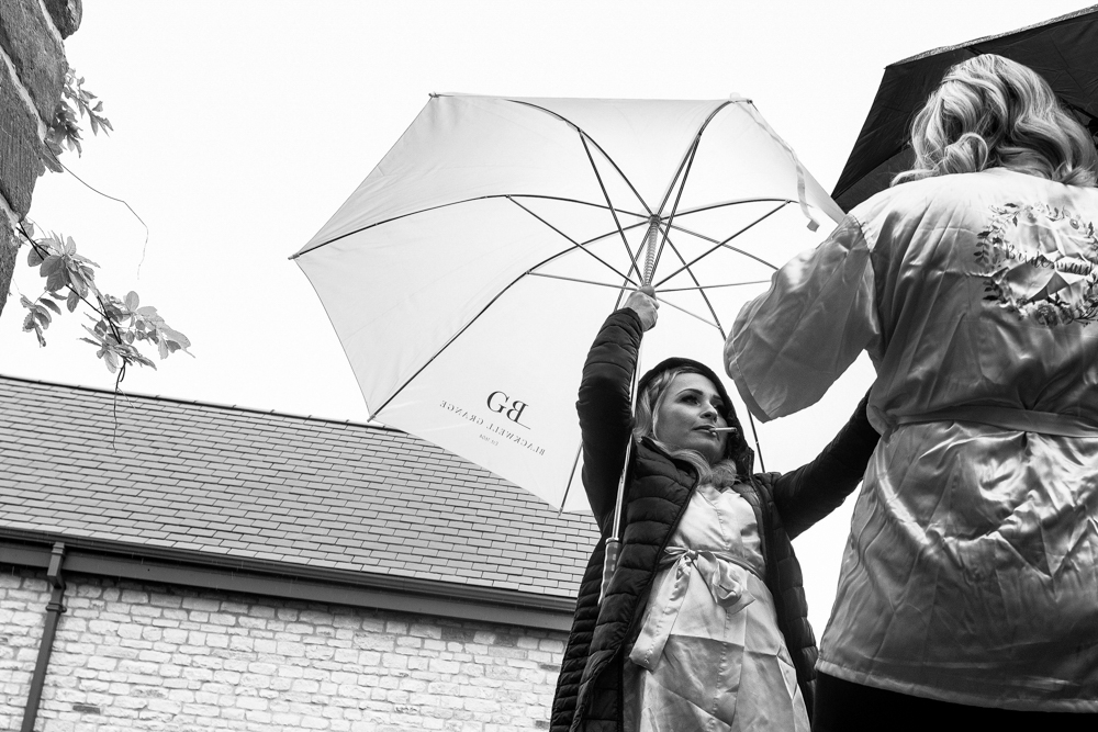 wedding guest chatting in the rain 