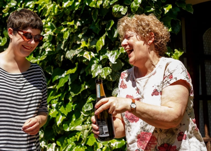 bride and mum laughing over a morning drink of champagne